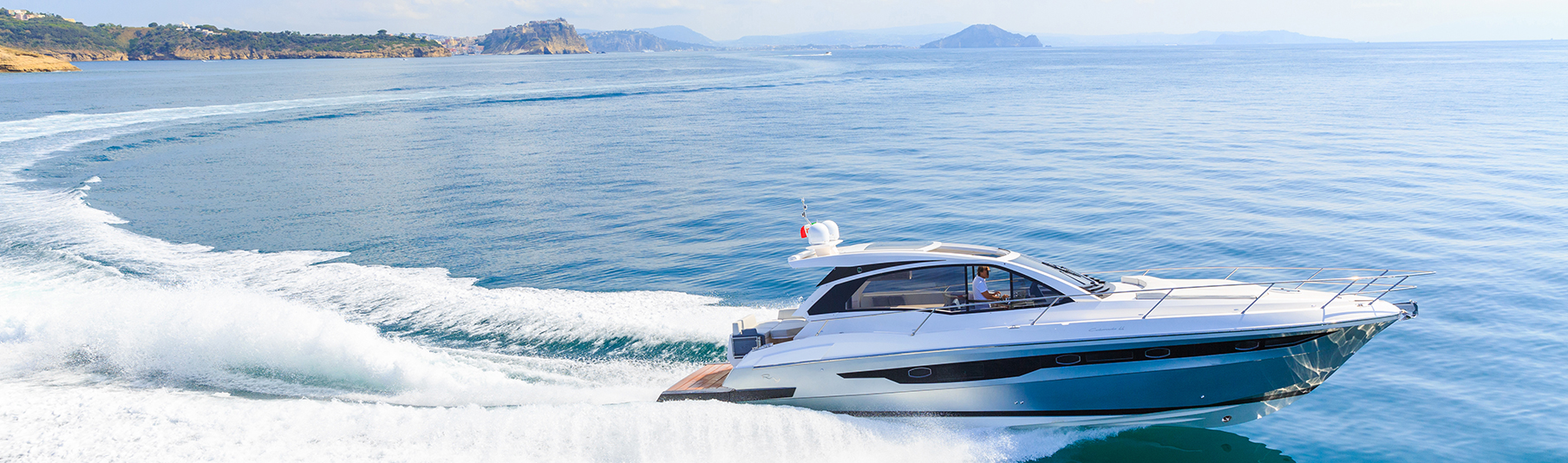 High Net Worth Insurance: A man driving a private boat across the sea