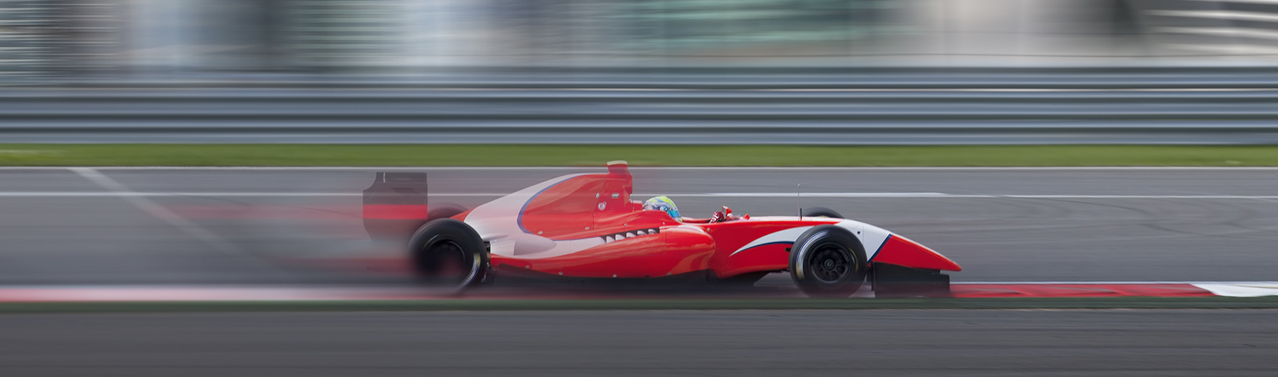 Motor Sports Insurance: A red racecar speeding down a track