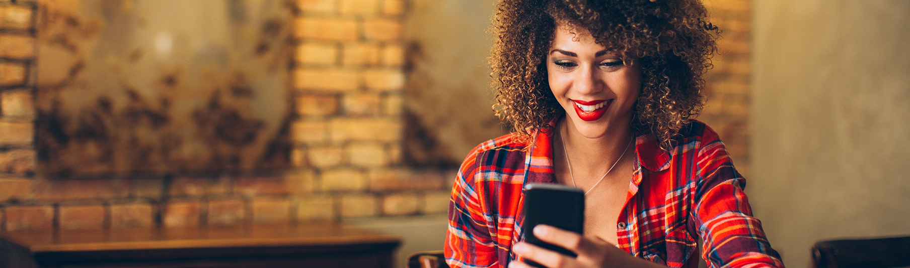 Personal Insurance: A young woman smiling while looking at her phone