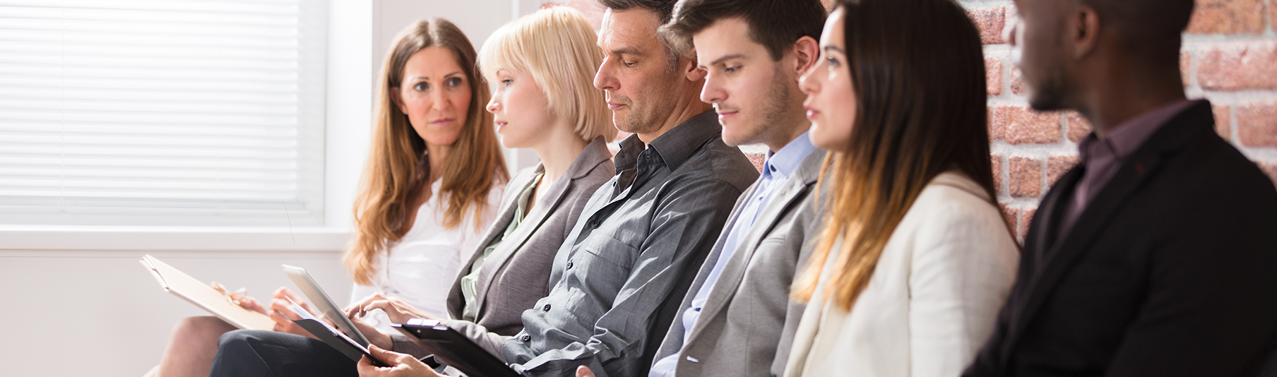 Recruitment Insurance: A row of candidates sitting and waiting to be interviewed